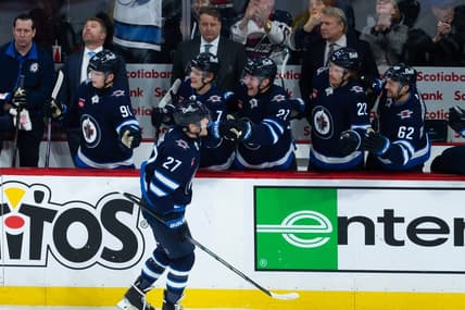 Jan 11, 2024; Winnipeg, Manitoba, CAN; Winnipeg Jets forward Nikolaj Ehlers (27) is congratulated by his team mates on his goal  against Chicago Blackhawks goalie Petr Mrazek (34) during the third period at Canada Life Centre. Mandatory Credit: Terrence Lee-USA TODAY Sports