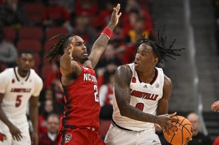 Jan 13, 2024; Louisville, Kentucky, USA;  Louisville Cardinals guard Mike James (0) controls the ball against North Carolina State Wolfpack guard Kam Woods (2) during the first half at KFC Yum! Center. Mandatory Credit: Jamie Rhodes-USA TODAY Sports