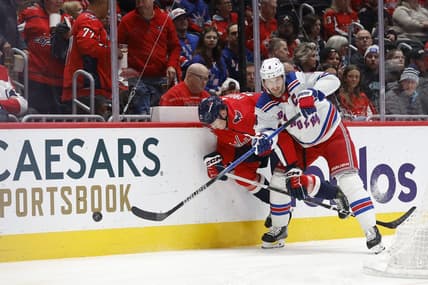 Jan 13, 2024; Washington, District of Columbia, USA; Washington Capitals center Aliaksei Protas (21) and New York Rangers defenseman Jacob Trouba (8) battle for the puck in the first period at Capital One Arena. Mandatory Credit: Geoff Burke-USA TODAY Sports