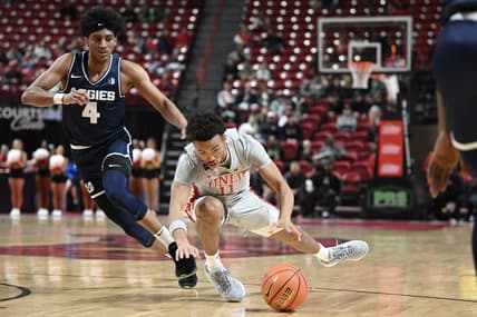 Jan 13, 2024; Las Vegas, Nevada, USA; UNLV Rebels guard Dedan Thomas Jr. (11) falls near Utah State Aggies guard Ian Martinez (4) during the first half at Thomas & Mack Center. Mandatory Credit: Candice Ward-USA TODAY Sports