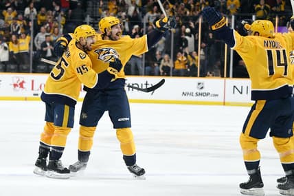 Jan 13, 2024; Nashville, Tennessee, USA; Nashville Predators defenseman Alexandre Carrier (45) and left wing Filip Forsberg (9) celebrate after the game-winning goal during the third period against the New York Islanders at Bridgestone Arena. Mandatory Credit: Christopher Hanewinckel-USA TODAY Sports