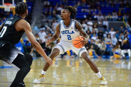 January 14, 2024; Los Angeles, California, USA; UCLA Bruins guard Dylan Andrews (2) controls the ball against Washington Huskies guard Koren Johnson (0) during the second half at Pauley Pavilion. Mandatory Credit: Gary A. Vasquez-USA TODAY Sports