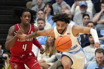 Jan 17, 2024; Chapel Hill, North Carolina, USA; Louisville Cardinals guard Ty-Laur Johnson (4) and North Carolina Tar Heels guard RJ Davis (4) fight for the ball in the first half at Dean E. Smith Center. Mandatory Credit: Bob Donnan-USA TODAY Sports