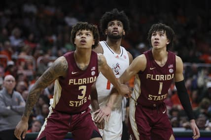 Jan 17, 2024; Coral Gables, Florida, USA; Miami Hurricanes forward Norchad Omier (15) looks on as Florida State Seminoles forward Cam Corhen (3) and guard Jalen Warley (1) defend during the second half at Watsco Center. Mandatory Credit: Sam Navarro-USA TODAY Sports