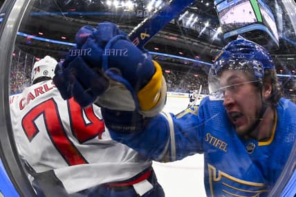 Jan 20, 2024; St. Louis, Missouri, USA;  St. Louis Blues left wing Jake Neighbours (63) checks Washington Capitals defenseman John Carlson (74) during the second period at Enterprise Center. Mandatory Credit: Jeff Curry-USA TODAY Sports