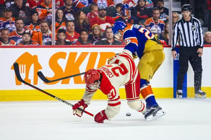 Jan 20, 2024; Calgary, Alberta, CAN; Calgary Flames right wing Matt Coronato (27) and Edmonton Oilers center Leon Draisaitl (29) battles for the puck during the second period at Scotiabank Saddledome. Mandatory Credit: Sergei Belski-USA TODAY Sports