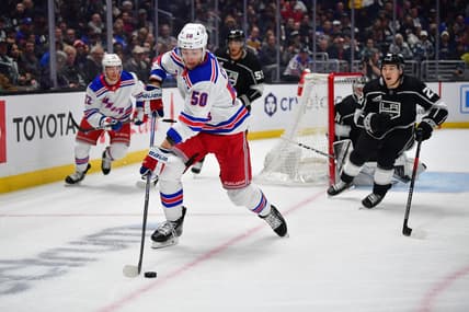 Jan 20, 2024; Los Angeles, California, USA; New York Rangers left wing Will Cuylle (50) moves the puck ahead of Los Angeles Kings defenseman Jordan Spence (21) durng the first period at Crypto.com Arena. Mandatory Credit: Gary A. Vasquez-USA TODAY Sports