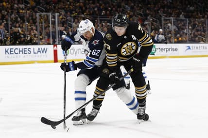 Jan 22, 2024; Boston, Massachusetts, USA; Boston Bruins defenseman Charlie McAvoy (73) and Winnipeg Jets right wing Nino Niederreiter (62) battle for a loose puck during the first period at TD Garden. Mandatory Credit: Winslow Townson-USA TODAY Sports