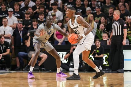 Jan 23, 2024; Orlando, Florida, USA; UCF Knights forward C.J. Walker (21) looks to pass against West Virginia Mountaineers forward Akok Akok (13) during the first half at Addition Financial Arena. Mandatory Credit: Mike Watters-USA TODAY Sports
