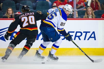 Jan 23, 2024; Calgary, Alberta, CAN; St. Louis Blues center Jordan Kyrou (25) controls the puck against Calgary Flames center Blake Coleman (20) during the first period at Scotiabank Saddledome. Mandatory Credit: Sergei Belski-USA TODAY Sports