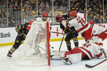 Jan 24, 2024; Boston, Massachusetts, USA; Boston Bruins right wing David Pastrnak (88) tries to bat the puck past Carolina Hurricanes goaltender Spencer Martin (41) while defenseman Brady Skjei (76) defends during the first period at TD Garden. Mandatory Credit: Bob DeChiara-USA TODAY Sports