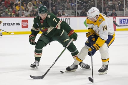 Jan 25, 2024; Saint Paul, Minnesota, USA; Minnesota Wild defenseman Brock Faber (7) poke-checks the puck away from Nashville Predators forward Gustav Nyquist (14) during the first period at Xcel Energy Center. Mandatory Credit: Nick Wosika-USA TODAY Sports