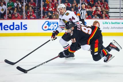 Jan 27, 2024; Calgary, Alberta, CAN; Calgary Flames center Nazem Kadri (91) controls the puck against Chicago Blackhawks defenseman Jaycob Megna (24) during the second period at Scotiabank Saddledome. Mandatory Credit: Sergei Belski-USA TODAY Sports