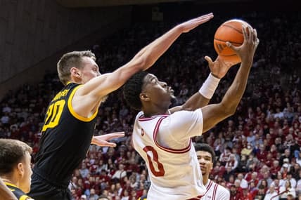 Jan 30, 2024; Bloomington, Indiana, USA; Indiana Hoosiers guard Xavier Johnson (0) shoots the ball while Iowa Hawkeyes forward Payton Sandfort (20) defends in the first half at Simon Skjodt Assembly Hall. Mandatory Credit: Trevor Ruszkowski-USA TODAY Sports