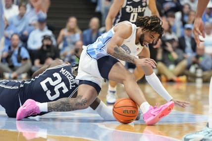 Feb 3, 2024; Chapel Hill, North Carolina, USA;  Duke Blue Devils forward Mark Mitchell (25) and North Carolina Tar Heels guard RJ Davis (4) fight for the ball in the first half at Dean E. Smith Center. Mandatory Credit: Bob Donnan-USA TODAY Sports