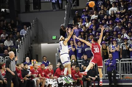 Feb 7, 2024; Evanston, Illinois, USA; Northwestern Wildcats guard Boo Buie (0) makes a three point basket over Nebraska Cornhuskers guard Keisei Tominaga (30)during the first half at Welsh-Ryan Arena. Mandatory Credit: David Banks-USA TODAY Sports