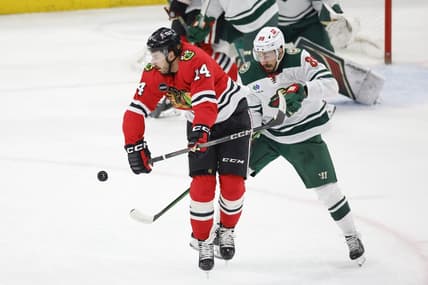 Feb 7, 2024; Chicago, Illinois, USA; Chicago Blackhawks left wing Boris Katchouk (14) battles for the puck with Minnesota Wild center Frederick Gaudreau (89) during the first period at United Center. Mandatory Credit: Kamil Krzaczynski-USA TODAY Sports