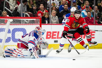 Feb 9, 2024; Chicago, Illinois, USA; Chicago Blackhawks center Philipp Kurashev (23) jumps off the ice as New York Rangers goaltender Igor Shesterkin (31) defends his goal during the first period at the United Center. Mandatory Credit: Daniel Bartel-USA TODAY Sports