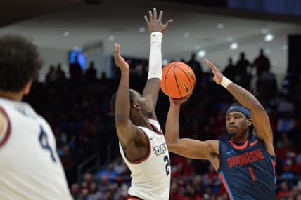 Feb 13, 2024; Dayton, Ohio, USA; Duquesne guard Jimmy Clark III (1) shoots the ball against Dayton Flyers guard Kobe Elvis (24) during the game at University of Dayton Arena. Mandatory Credit: Matt Lunsford-USA TODAY Sports