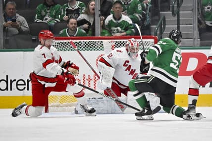 Feb 13, 2024; Dallas, Texas, USA; Carolina Hurricanes defenseman Dmitry Orlov (7) and goaltender Pyotr Kochetkov (52) face a shot by Dallas Stars center Wyatt Johnston (53) during the first period at the American Airlines Center. Mandatory Credit: Jerome Miron-USA TODAY Sports