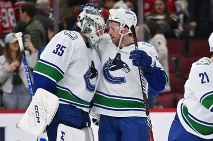 Feb 13, 2024; Chicago, Illinois, USA; Vancouver Canucks goaltender Thatcher Demko (35) and forward Elias Lindholm (23) celebrate after defeating the Chicago Blackhawks 4-2 at United Center. Mandatory Credit: Jamie Sabau-USA TODAY Sports