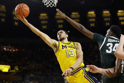 Feb 17, 2024; Ann Arbor, Michigan, USA; Michigan Wolverines forward Olivier Nkamhoua (13) shoots on Michigan State Spartans forward Xavier Booker (34) in the first half  at Crisler Center. Mandatory Credit: Rick Osentoski-USA TODAY Sports