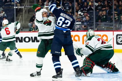 Feb 20, 2024; Winnipeg, Manitoba, CAN; Winnipeg Jets forward Nino Niederreiter (62) jostles for position with Minnesota Wild defenseman Alex Goligoski (33) during the second period at Canada Life Centre. Mandatory Credit: Terrence Lee-USA TODAY Sports