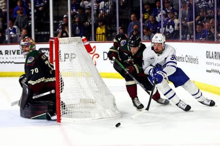 Feb 21, 2024; Tempe, Arizona, USA; Toronto Maple Leafs center Auston Matthews (34) moves the puck against the net against Arizona Coyotes defenseman Juuso Valimaki (4) during the first period at Mullett Arena. Mandatory Credit: Mark J. Rebilas-USA TODAY Sports