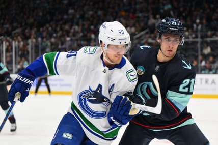 Feb 22, 2024; Seattle, Washington, USA; Vancouver Canucks center Elias Pettersson (40) and Seattle Kraken center Alex Wennberg (21) during the first period at Climate Pledge Arena. Mandatory Credit: Steven Bisig-USA TODAY Sports