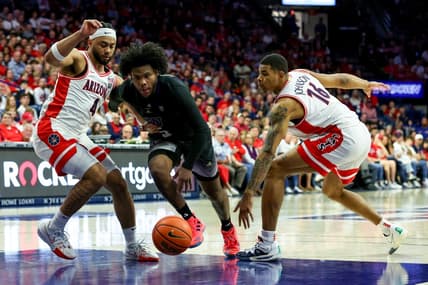Feb 24, 2024; Tucson, Arizona, USA; Washington Huskies guard Sahvir Wheeler (5) drives to the basket against Arizona Wildcats guard Kylan Boswell (4) and forward Keshad Johnson (16) during the first half at McKale Center. Mandatory Credit: Zachary BonDurant-USA TODAY Sports