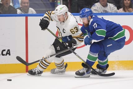 Feb 24, 2024; Vancouver, British Columbia, CAN;  Vancouver Canucks defenseman Filip Hronek (17) checks Boston Bruins forward Brad Marchand (63) during the second period at Rogers Arena. Mandatory Credit: Anne-Marie Sorvin-USA TODAY Sports