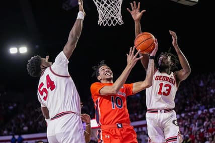 Feb 24, 2024; Athens, Georgia, USA; Auburn Tigers guard Chad Baker-Mazara (10) goes to the basket between Georgia Bulldogs center Russel Tchewa (54) and forward Dylan James (13) at Stegeman Coliseum. Mandatory Credit: Dale Zanine-USA TODAY Sports