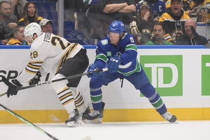 Feb 24, 2024; Vancouver, British Columbia, CAN;  Vancouver Canucks forward Brock Boeser (6) battles for the puck against Boston Bruins defenseman Derek Forbort (28) during the first period at Rogers Arena. Mandatory Credit: Anne-Marie Sorvin-USA TODAY Sports