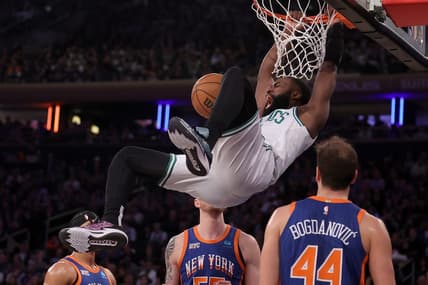 Feb 24, 2024; New York, New York, USA; Boston Celtics guard Jaylen Brown (7) hangs on the rim after a dunk against New York Knicks guard Josh Hart (3) and center Isaiah Hartenstein (55) and forward Bojan Bogdanovic (44) during the second quarter at Madison Square Garden. Mandatory Credit: Brad Penner-USA TODAY Sports
