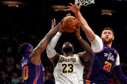 Feb 25, 2024; Phoenix, Arizona, USA; Los Angeles Lakers forward LeBron James (23) shoots the ball against Phoenix Suns forward Royce O'Neale (00) and center Jusuf Nurkic (20) during the fourth quarter at Footprint Center. Mandatory Credit: Mark J. Rebilas-USA TODAY Sports