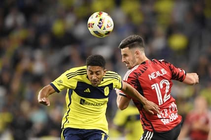 Feb 25, 2024; Nashville, Tennessee, USA; Nashville SC forward McKinze Gaines (17) goes up for a header against New York Red Bulls defender Dylan Nealis (12) at Geodis Park. Mandatory Credit: Steve Roberts-USA TODAY Sports