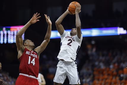 Jan 24, 2024; Charlottesville, Virginia, USA; Virginia Cavaliers guard Reece Beekman (2) shoots the ball as North Carolina State Wolfpack guard Casey Morsell (14) defends in overtime at John Paul Jones Arena. Mandatory Credit: Geoff Burke-USA TODAY Sports