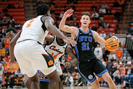 Feb 17, 2024; Stillwater, Oklahoma, USA; Brigham Young Cougars guard Trevin Knell (21) drives to the basket around Oklahoma State Cowboys guard Jamyron Keller (14) and Oklahoma State Cowboys forward Eric Dailey Jr. (2) during the second half at Gallagher-Iba Arena. Mandatory Credit: William Purnell-USA TODAY Sports