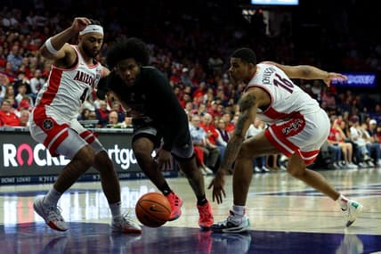 Feb 24, 2024; Tucson, Arizona, USA; Washington Huskies guard Sahvir Wheeler (5) drives to the net against Arizona Wildcats guard Kylan Boswell (4) and forward Keshad Johnson (16) during the first half at McKale Center. Mandatory Credit: Zachary BonDurant-USA TODAY Sports