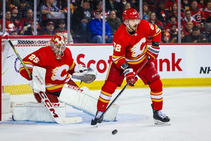 Mar 4, 2024; Calgary, Alberta, CAN; Calgary Flames defenseman MacKenzie Weegar (52) controls the puck in front of Calgary Flames goaltender Jacob Markstrom (25) during the first period against the Seattle Kraken at Scotiabank Saddledome. Mandatory Credit: Sergei Belski-USA TODAY Sports