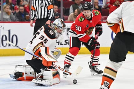 Mar 12, 2024; Chicago, Illinois, USA; Anaheim Ducks goaltender John Gibson (36) tracks a shot in the first period as Chicago Blackhawks forward Tyler Johnson (90) waits for the rebound at United Center. Mandatory Credit: Jamie Sabau-USA TODAY Sports