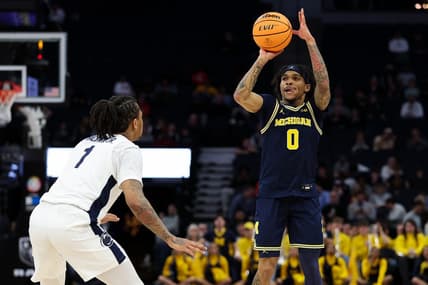 Mar 13, 2024; Minneapolis, MN, USA; Michigan Wolverines guard Dug McDaniel (0) shoots as Penn State Nittany Lions guard Ace Baldwin Jr. (1) defends during the first half at Target Center. Mandatory Credit: Matt Krohn-USA TODAY Sports