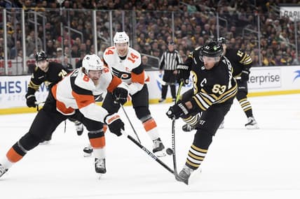 Mar 16, 2024; Boston, Massachusetts, USA; Boston Bruins left wing Brad Marchand (63) shoots the puck while Philadelphia Flyers defenseman Travis Sanheim (6) defends during the first period at TD Garden. Mandatory Credit: Bob DeChiara-USA TODAY Sports