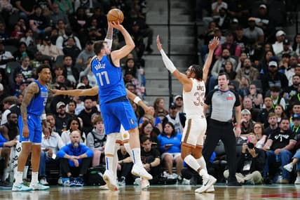 Mar 19, 2024; San Antonio, Texas, USA;  Dallas Mavericks guard Luka Doncic (77) shoots over San Antonio Spurs guard Tre Jones (33) in the first half at Frost Bank Center. Mandatory Credit: Daniel Dunn-USA TODAY Sports