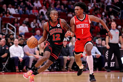 Mar 21, 2024; Houston, Texas, USA; Chicago Bulls guard Ayo Dosunmu (12) handles the ball against Houston Rockets forward Amen Thompson (1) during the second quarter at Toyota Center. Mandatory Credit: Erik Williams-USA TODAY Sports