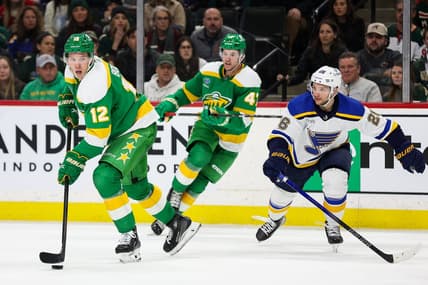 Mar 23, 2024; Saint Paul, Minnesota, USA; Minnesota Wild left wing Matt Boldy (12) skates with the puck as St. Louis Blues left wing Nathan Walker (26) defends during the third period at Xcel Energy Center. Mandatory Credit: Matt Krohn-USA TODAY Sports