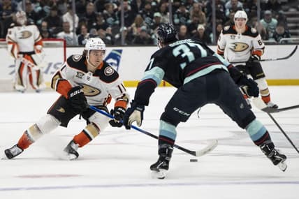 Mar 26, 2024; Seattle, Washington, USA; Anaheim Ducks forward Trevor Zegras (11) skates against Seattle Kraken forward Yanni Gourde (37) during the first period at Climate Pledge Arena. Mandatory Credit: Stephen Brashear-USA TODAY Sports