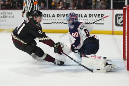 Mar 26, 2024; Tempe, Arizona, USA; Columbus Blue Jackets goaltender Elvis Merzlikins (90) makes the save on Arizona Coyotes right wing Josh Doan (91) in the second period at Mullett Arena. Mandatory Credit: Rick Scuteri-USA TODAY Sports