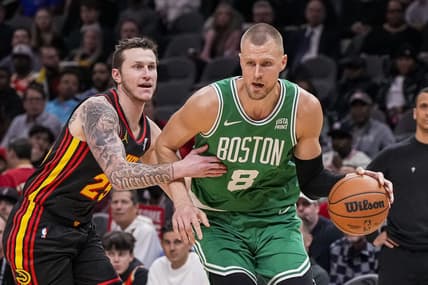 Mar 28, 2024; Atlanta, Georgia, USA; Boston Celtics center Kristaps Porzingis (8) dribbles against Atlanta Hawks guard Garrison Mathews (25) during the first half at State Farm Arena. Mandatory Credit: Dale Zanine-USA TODAY Sports
