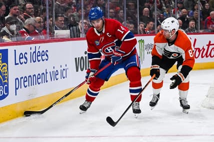Mar 28, 2024; Montreal, Quebec, CAN; Montreal Canadiens center Nick Suzuki (14) plays the puck against Philadelphia Flyers defenseman Cam York (8) during the second period at Bell Centre. Mandatory Credit: David Kirouac-USA TODAY Sports